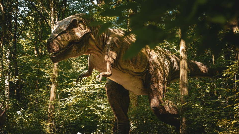 Un dinosaurio entre la maleza de una selva